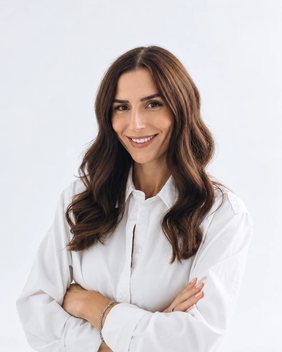 Sierra Schubach in a white shirt, arms crossed, smiling